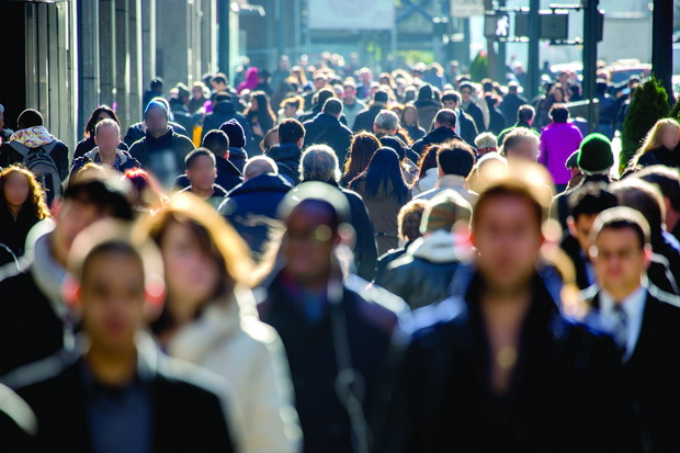 Anonymous crowd of people walking on city street