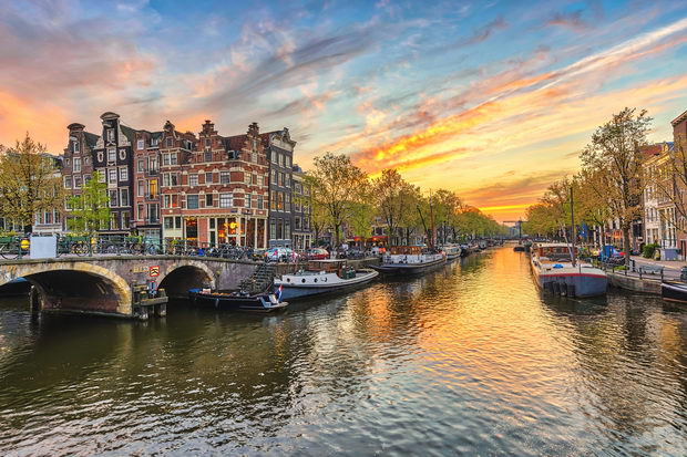 Amsterdam sunset city skyline at canal waterfront, Amsterdam, Netherlands