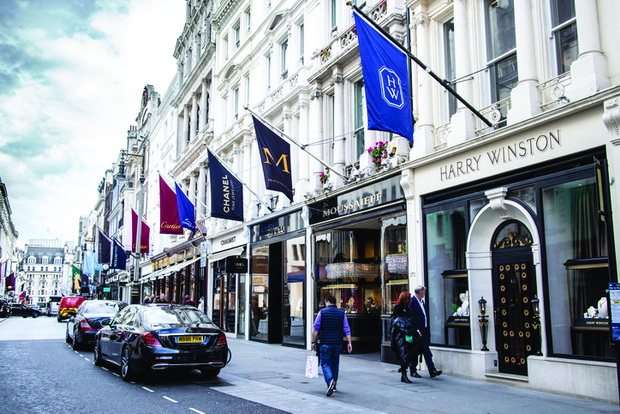 People walking by high end exclusive jewellery stores such as Chanel, Cartier in New Bond, London, England