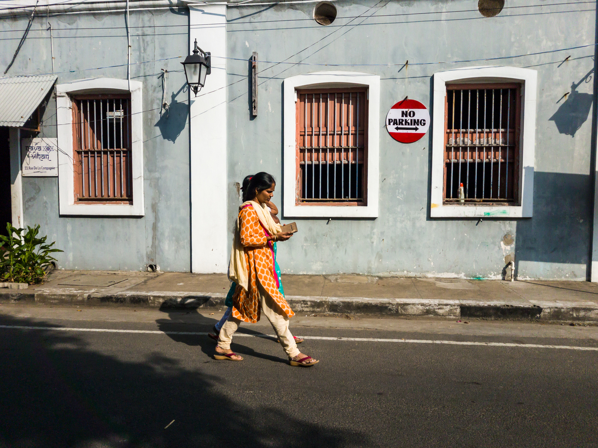 Woman walking past French architecture in Pondicherry