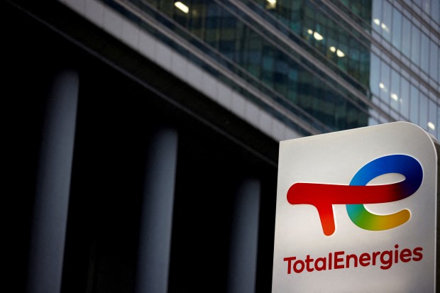 FILE PHOTO: The logo of French oil and gas company TotalEnergies is pictured at an electric car charging station in Courbevoie